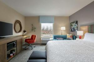 ジョンズクリークにあるHampton Inn And Suites By Hilton Johns Creekのベッドとテレビが備わるホテルルームです。