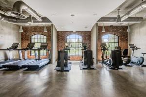 a gym with treadmills and exercise equipment in a brick wall at NYLO Las Colinas Hotel, Tapestry Collection by Hilton in Irving