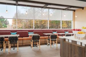 a restaurant with tables and chairs in front of a large window at Tru By Hilton Greenville Woodruff Road, SC in Greenville