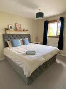 a bedroom with a large white bed with a window at Cozy bedroom in shared accommodation with free parking in Edinburgh