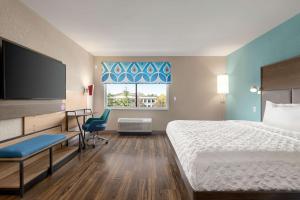 a hotel room with a bed and a flat screen tv at Tru Lawrenceville Atlanta I85 Sugarloaf in Lawrenceville
