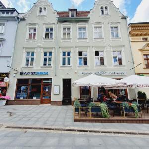 un edificio con tavoli e ombrelloni di fronte ad esso di Mostowa 3 a Bydgoszcz