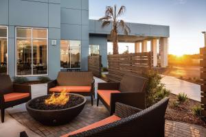 een patio met stoelen en een vuurplaats voor een gebouw bij Hilton Garden Inn Sacramento Airport Natomas in Sacramento