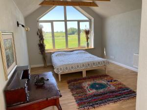 ein Schlafzimmer mit einem Bett und einem großen Fenster in der Unterkunft Drustu atpūtas nams Magazīna in Drusti
