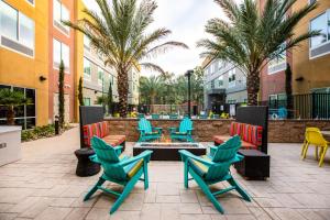 卡爾斯巴德的住宿－Home2 Suites By Hilton Carlsbad, Ca，一个带椅子和火坑的庭院,并种植了棕榈树
