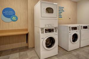 - une buanderie avec deux lave-linge et un panneau dans l'établissement Tru By Hilton Oxford, à Oxford