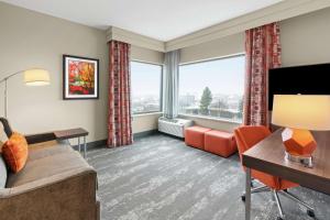 Hampton Inn & Suites Spokane Downtown-South في سبوكان: غرفة معيشة مع أريكة وتلفزيون