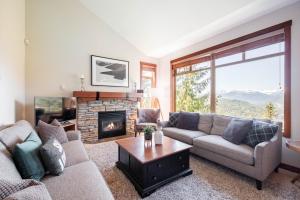 a living room with a couch and a fireplace at Taluswood Bluffs by Outpost Whistler in Whistler