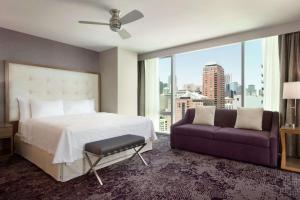 een slaapkamer met een bed, een bank en een raam bij Homewood Suites By Hilton Chicago Downtown South Loop in Chicago