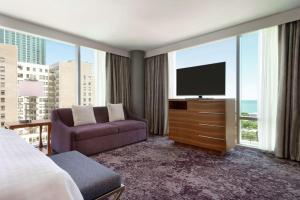 a hotel room with a tv and a purple couch at Homewood Suites By Hilton Chicago Downtown South Loop in Chicago