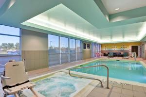 uma piscina com uma cadeira num quarto de hotel em Tru By Hilton Idaho Falls Id em Idaho Falls