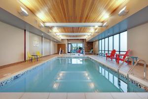 uma piscina com cadeiras e mesas coloridas em Home2 Suites By Hilton Yakima Airport em Yakima