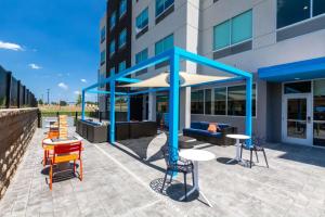 a building with a patio with tables and chairs at Tru By Hilton Seneca Clemson Sc in Seneca
