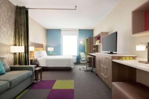 um quarto de hotel com uma cama e uma televisão em Home2 Suites By Hilton Overland Park, Ks em Overland Park