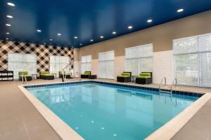 a swimming pool in a hotel room with chairs at Hampton Inn & Suites Ocean City West in Ocean City