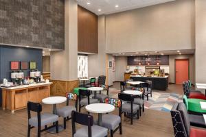 a restaurant with tables and chairs and a counter at Hampton Inn & Suites Ocean City West in Ocean City