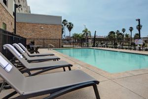 a swimming pool with lounge chairs next to a building at Hampton Inn Weslaco in Weslaco
