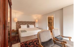a bedroom with a white bed and two chairs at Casa As Macieiras in Bolembre de Baixo