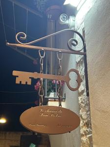 a sign hanging on a wall with a chain at Le Chiavi di San Pietro in Noci