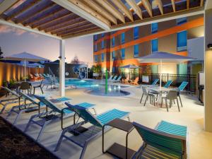 a patio with chairs and tables and a pool at Home2 Suites By Hilton Chattanooga Hamilton Place in Chattanooga