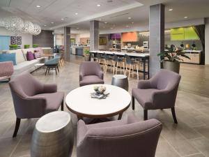 a lobby with chairs and a table and a counter at Home2 Suites By Hilton Chattanooga Hamilton Place in Chattanooga