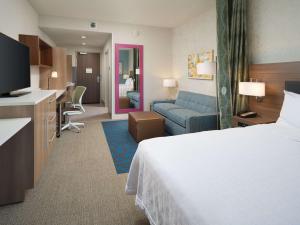 a hotel room with a bed and a living room at Home2 Suites By Hilton Chattanooga Hamilton Place in Chattanooga