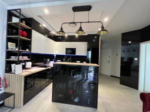 a kitchen with black and white cabinets and a counter at Towarowa - Milionowa 39 in Poznań