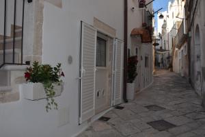 eine Gasse mit weißen Gebäuden, einem Fenster und Blumen in der Unterkunft Le Chiavi di San Pietro in Noci