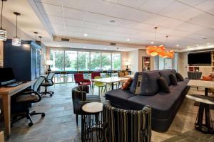 uma sala de estar com um sofá, mesas e cadeiras em Home2 Suites By Hilton Georgetown em Georgetown