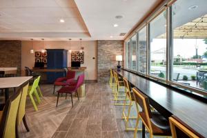 a dining room with tables and chairs and windows at Home2 Suites By Hilton Georgetown in Georgetown