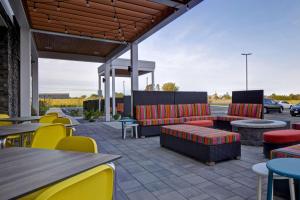 d'une terrasse avec des meubles colorés, des tables et des chaises. dans l'établissement Home2 Suites By Hilton Loves Park Rockford, à Loves Park