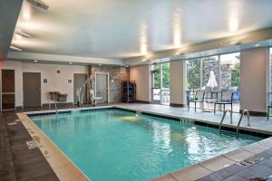 a large swimming pool with blue water in a building at Home2 Suites By Hilton Georgetown in Georgetown