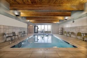 a pool in a building with a swimming pool at Home2 Suites By Hilton Loves Park Rockford in Loves Park