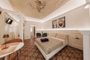 a bedroom with a bed and a ceiling with a painting at I Mori Apartments in Cefalù
