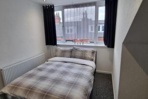 a small bed in a room with a window at Your Home away from Home. in Headingley