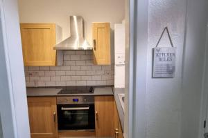 a kitchen with wooden cabinets and a stove top oven at Your Home away from Home. in Headingley