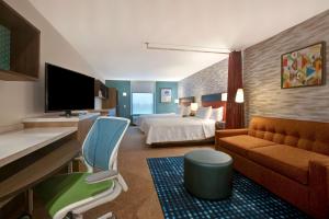 um quarto de hotel com uma cama e um sofá em Home2 Suites By Hilton Loves Park Rockford em Loves Park