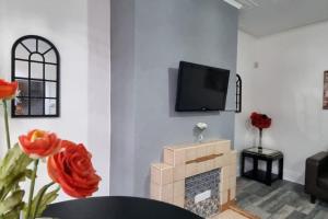 a living room with a fireplace and a tv on a wall at Your Home away from Home. in Headingley