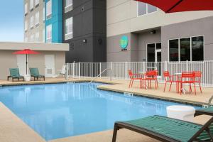 uma piscina com cadeiras e uma mesa e guarda-sol em Tru By Hilton Lake City em Lake City