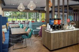 un ristorante con bar, tavoli e sedie di Tru By Hilton Lake City a Lake City