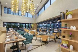 un restaurante con mesas, sillas y ventanas en Doubletree By Hilton Afyonkarahisar, en Afyon