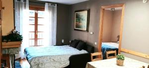 a bedroom with a bed and a mirror and a table at Apartamento El Refugio de Sara in Benasque