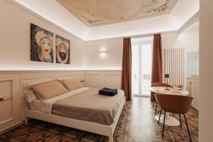 een slaapkamer met een bed, een tafel en een bureau bij I Mori Apartments in Cefalù