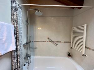W łazience znajduje się biała wanna i prysznic. w obiekcie La Llardana w mieście Benasque