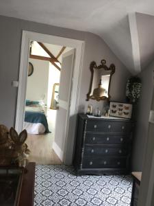 a room with a dresser and a mirror and a bedroom at 2 DESCARTES in La Flèche