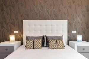 ein Schlafzimmer mit einem großen weißen Bett mit zwei Lampen in der Unterkunft BNBHolder Apartamentos en Sol Confort 9 in Madrid