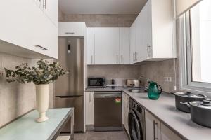 eine Küche mit weißen Schränken und einer Vase aus Blumen in der Unterkunft BNBHolder Apartamentos en Sol Confort 9 in Madrid
