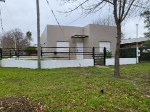 uma casa branca com uma cerca preta num quintal em Veronica mini home 1 em Verónica