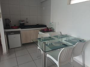 a kitchen with a glass table and chairs in it at Apartamento West Flat AP213 in Mossoró +9 photos