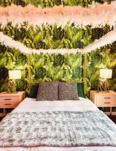 a bedroom with a bed with a green leafy wall at Dreaming With Dolly - Luxe Stay Near Broadway in Nashville
